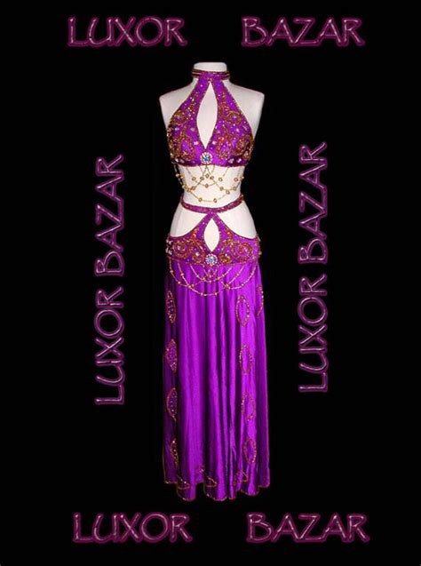 A Woman In A Purple Belly Dance Outfit With The Words Luxury Bazaar On It S Chest
