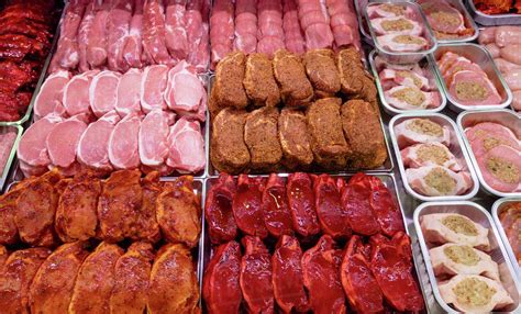 Variety Of Marinated Meat At Display Counter In Butchers Shop Stock