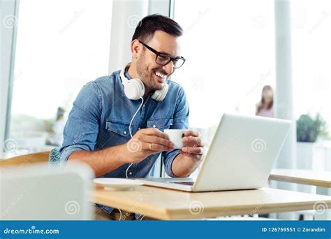 Young Freelancer Working On Laptop At The Coffeehouse Stock Image