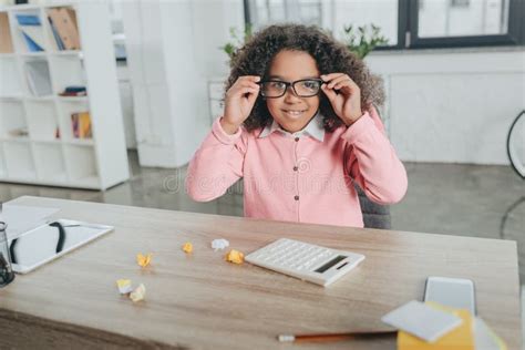 Cheerful African American Girl In Eyeglasses Sitting At Table With