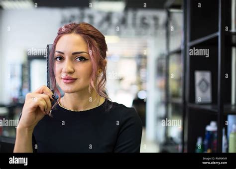 Portrait Of The Beautiful Young Hairdresser In Beauty Salon Stock Photo