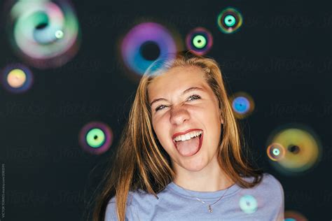 Studio Portrait Of Cute Teen Girl Looking At Camera Soap Bubbles Are