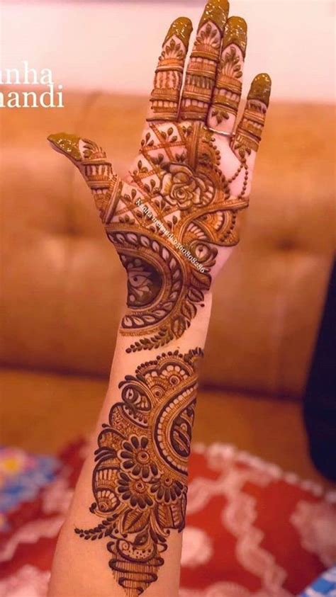 A Womans Hand With Henna On It And The Words Mehndi Written In Arabic