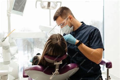 Premium Photo Doctor Dentist Treats The Teeth Of A Patient Under A