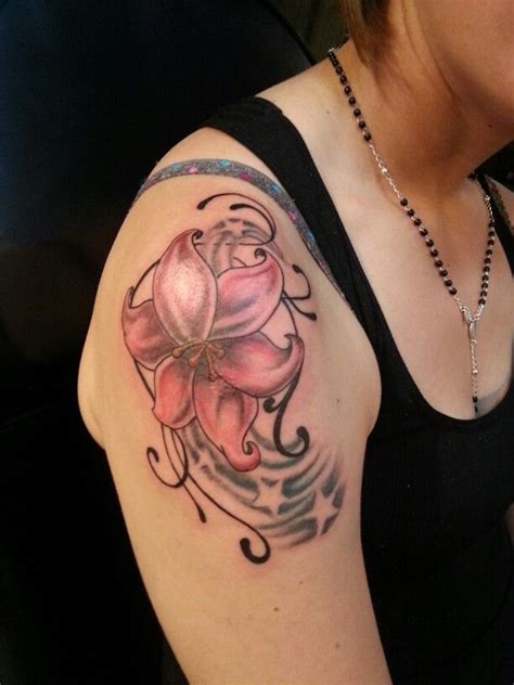 A Woman With A Tattoo On Her Arm Has A Pink Flower And Swirls In The