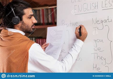 Arab Teacher Teaching English Writing Grammar Rules On Blackboard