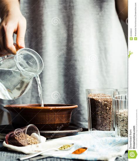 Pouring Water From A Glass Jug Into A Bowl Hands Stock Image Image