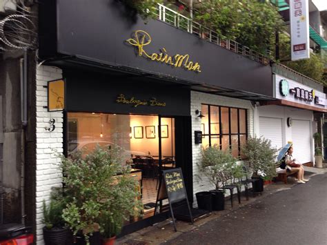 An Outside View Of A Restaurant With Potted Plants On The Side Of The