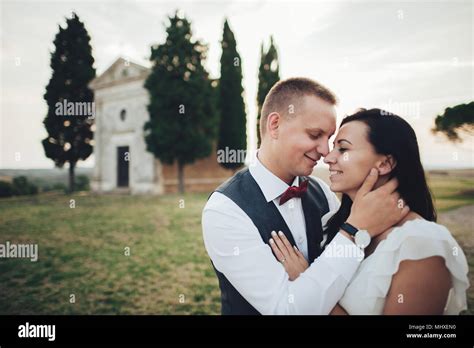 happy stylish smiling couple walking and kissing in tuscany italy on their wedding day stock