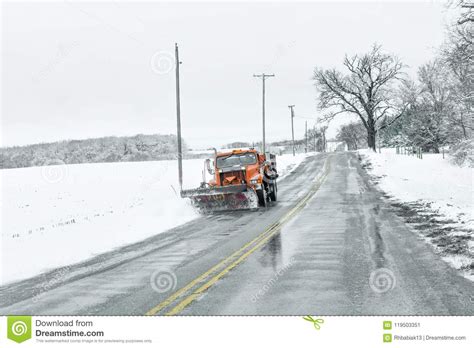 Snow Plow Truck Clearing Icy Road After Winter Snowstorm Blizzard For