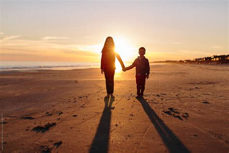 Brother And Sister Holding Hands With Sun Setting Behind Them By Stocksy Contributor Jakob