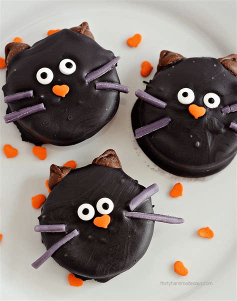 Pipe mummy bandages over the top of the oreos with the melted candy. Halloween Cat Oreo Cookies