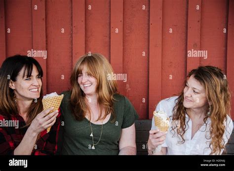 Three Women Sitting On A Bench Eating Ice Cream Stock Photo Alamy