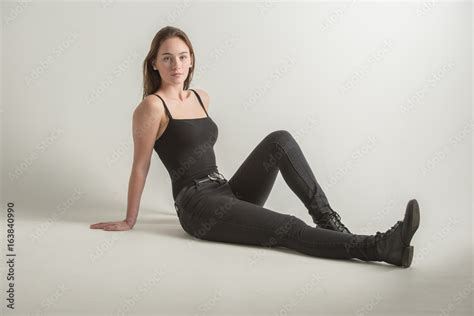 Young Woman On White Background Sitting Leaning Back Full Body In Black