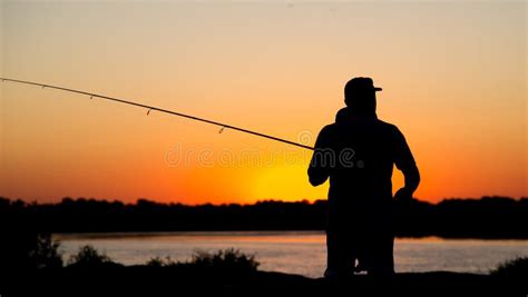 Silhouette Of A Man With A Fishing Rod At Sunset Stock Photo Image Of