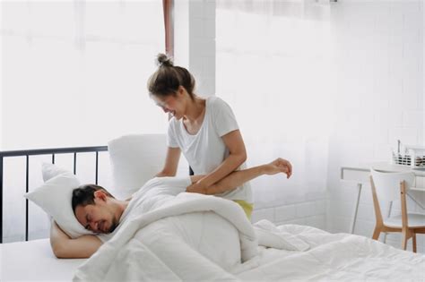 Premium Photo Funny Lovely Couple Wife Trying To Wake Husband Up In The Morning