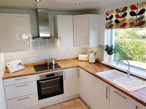 Looking for kitchen decorating ideas? White gloss units, Wooden worktops, Grey tiles (With ...