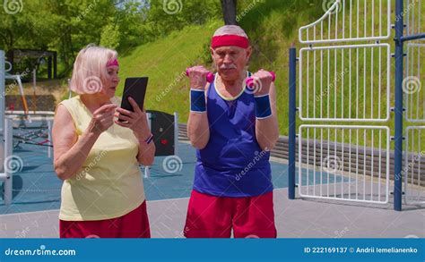 Senior Old Woman Grandmother Coach Teaching Grandfather With Sport Weightlifting Cardio