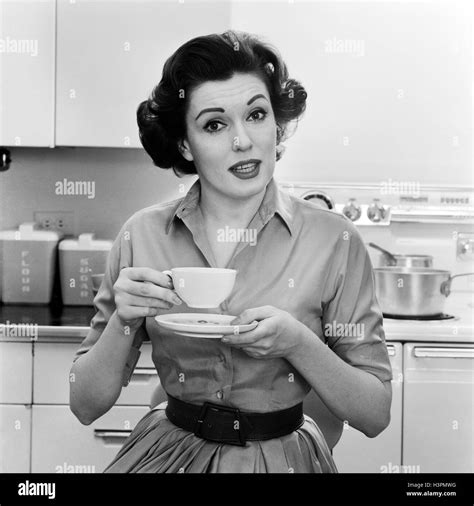 1950s 1960s Portrait Woman Housewife In Kitchen Drinking Cup Of Coffee