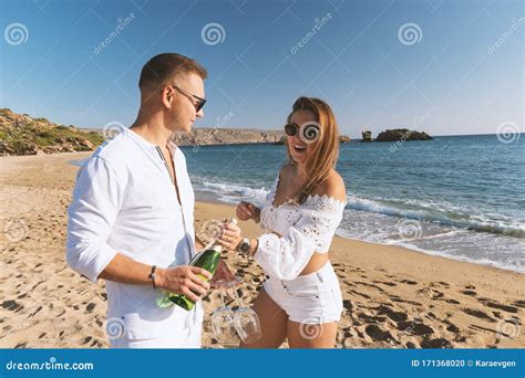 Happy Couple With Champagne On The Beach Summer Vacations Concept