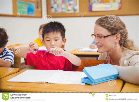 Pretty Teacher Helping Pupil In Classroom Stock Image Image Of Female