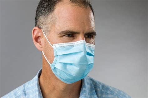 Remove a used mask holding only the ear loops. TYPE IIR Surgical Face Mask TOP-SPEC Medical Grade ...