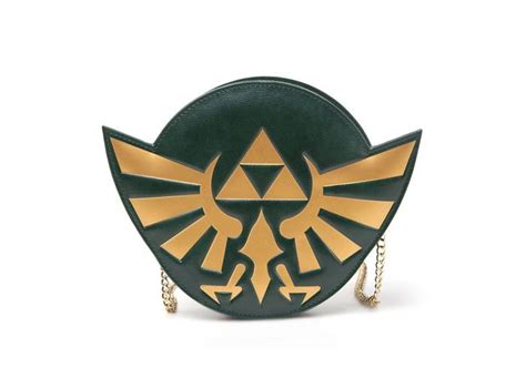 The Legend Of Zelda Purse Is Shown In Gold And Black With An Emblem On It