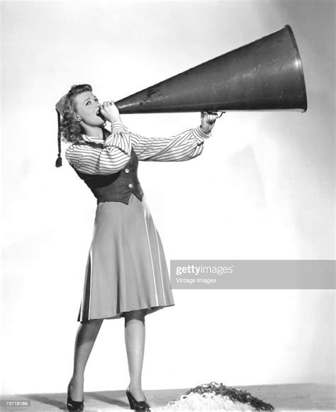 Portrait Of A Cheerleader As She Shouts Into A Large Megaphone While