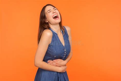 Hilarious Laughter Joyful Brunette Woman In Denim Dress Holding Her Belly Bursting Into
