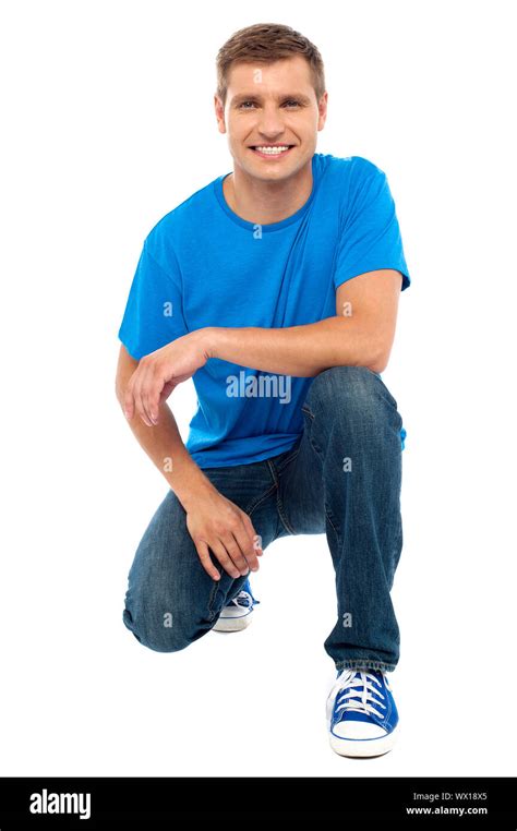 Casual Cool Young Guy Semi Seated On Floor Isolated Against White