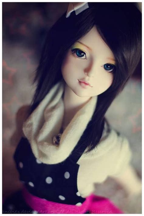 A Doll With Long Black Hair And Blue Eyes Wearing A Polka Dot Shirt