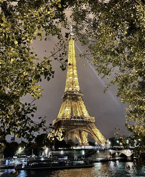 The Eiffel Tower Is Lit Up At Night With Lights On Its Sides