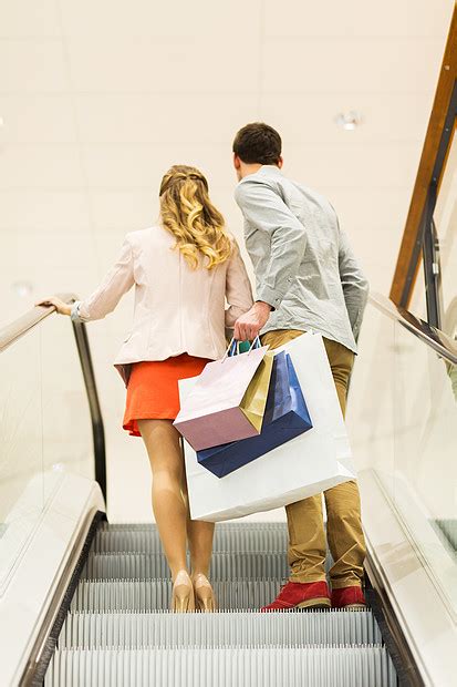 销售消费主义人的快乐的轻夫妇购物袋上升自动扶梯手指商场高清图片下载 正版图片300577513 摄图网