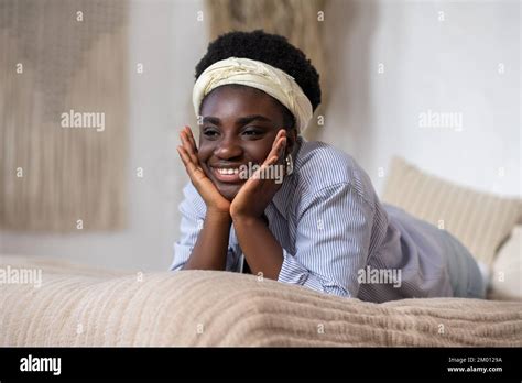 Day Dreaming African American Woman Laying On Bed And Looking Dreamy