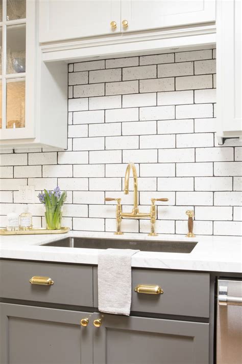 White Subway Tile White Cabinetry Dark Grey Lower Cabinets Gold