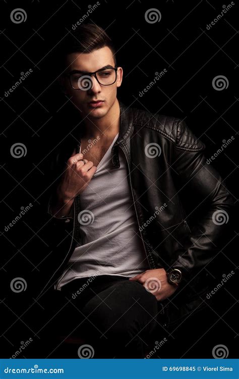 Man In Black Leather Jacket Wearing Glasses Pulling His Shirt Stock