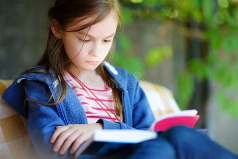 Cute Little Girl Reading A Book Outdoors Stock Photo Image Of Enjoy