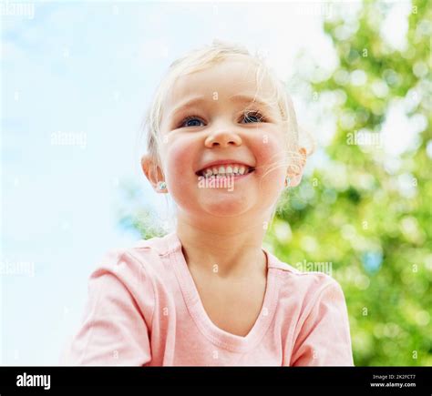 Fun Under The Summer Sun Shot Of A Cute Little Girl Smiling While