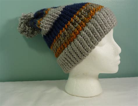 A White Mannequin Head Wearing A Multicolored Knitted Beanie Hat