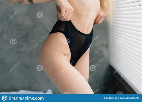 Curvy Woman In Black Panties On A Bikini Zone Stands Near The Window