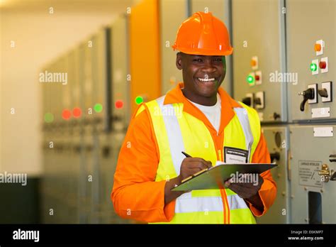 Happy African American Engineer Standing In Front Of Control Panel