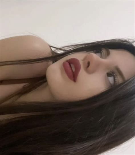A Woman With Long Brown Hair And Red Lipstick On Her Face Posing For The Camera
