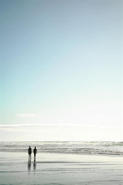 Two People Standing On Seashore · Free Stock Photo