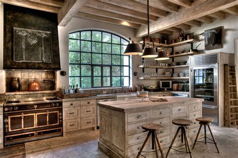 The ceiling features heavy, exposed wooden beams in a dark wood finish and a hanging wrought iron decorative candelabra. Rustic Farmhouse Kitchen softened by white-washed Wood ...