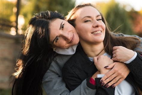Dos Chicas Morenas Caucásicas Se Abrazan En El Soleado Parque De Otoño Feliz Pareja De