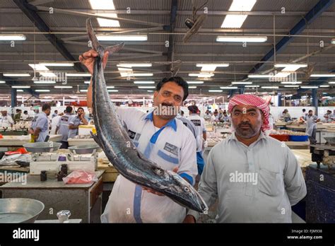 Fish Market Worker Holding A Large Kingfish At Dubai Fish Market In