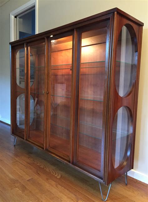The corner design gives the curio cabinet the same amount of storage space. Mid Century Curio Cabinet by Kent Coffey at EPOCH