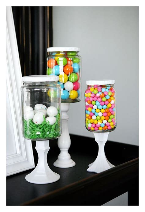 Three Glass Jars Filled With Candy Sitting On Top Of A Table Next To A