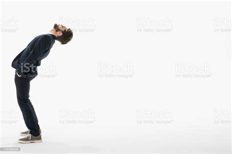 Businessman Leaning Backward Against White Background Stock Photo