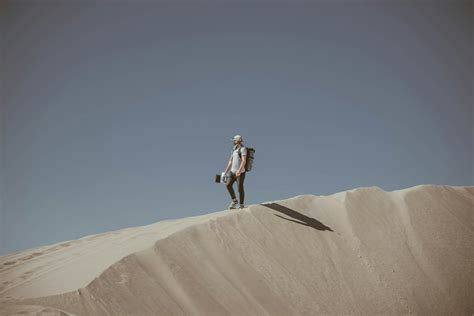 Man Standing In Desert During Daytime Photo Free Soil Image On Unsplash